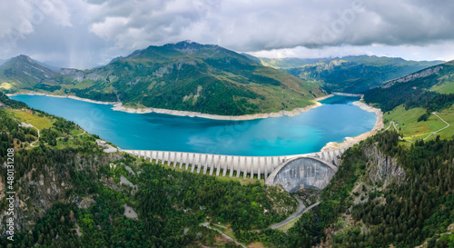 Hydroelectric dam and reservoir lake in French Alps mountains. Renewable energy and sustainable development with hydropower generation. Aerial view. photo