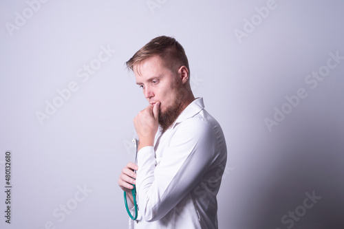 Male doctor in laboratory coat on gray background