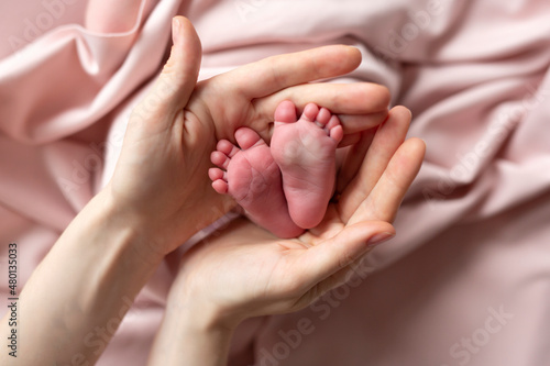 Newborn feet in mother's hands