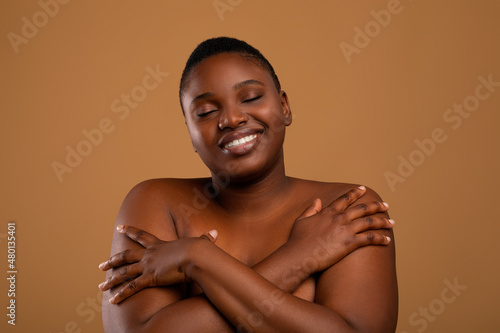 Portrait of beautiful plus size black woman embracing herself