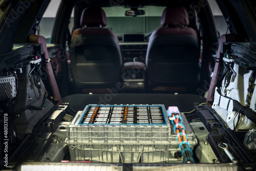 Electric car lithium battery pack and power connections on EV car background.	 photo