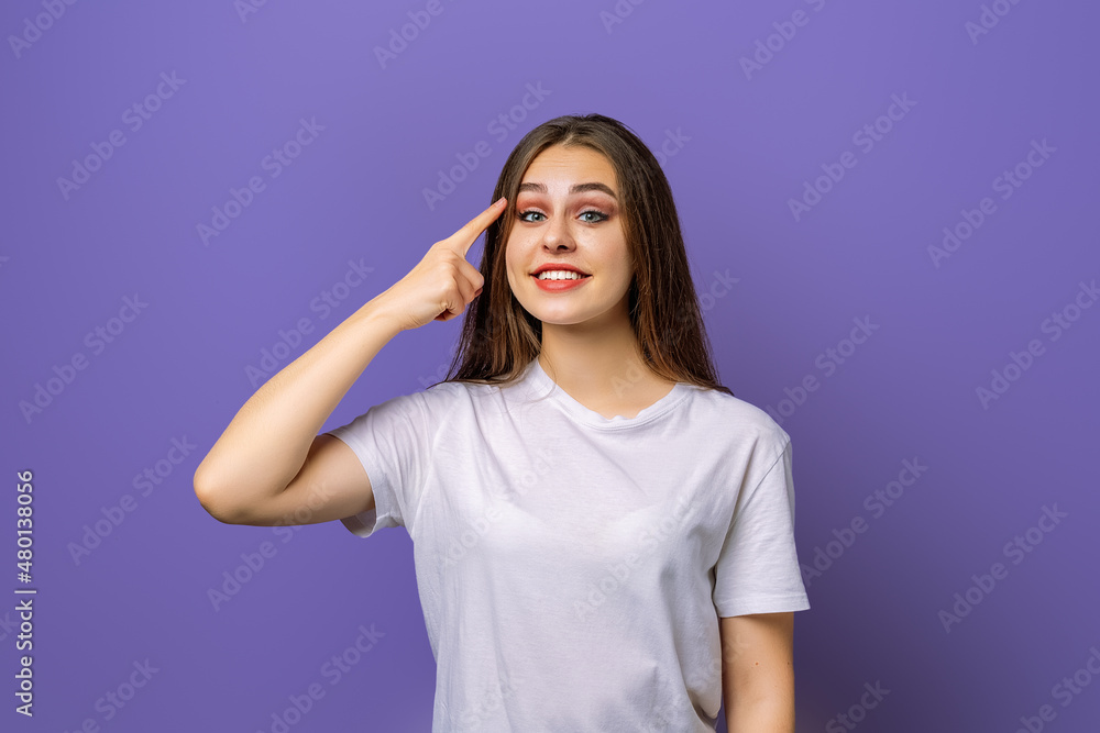 Eureka, finally got answer on question. Attractive pleasant young brunette woman holding index finger on temple and looking at camera with a happy smile on face, recalling or remembering Eureka, finally got answer on question. Attractive pleasant young brunette woman holding index finger on temple and looking at camera with a happy smile on face, recalling or remembering