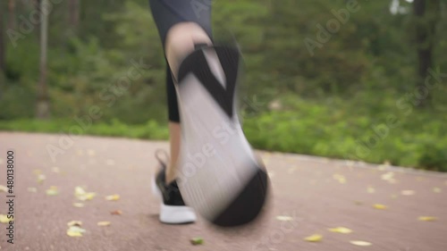 A girl athlete runs along a forest path.