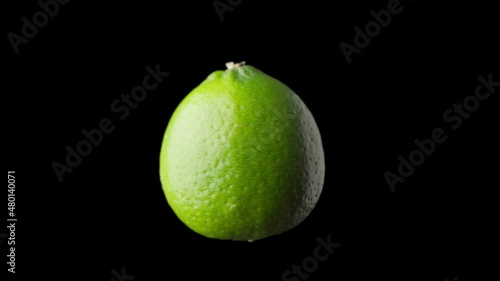 Lime rotates on a black background, isolated.