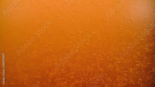 Close-up of the beer in the glass, the bubbles slowly rising.