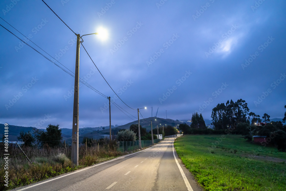 Illuminated rural road in the cloudy evening, central Portugal
