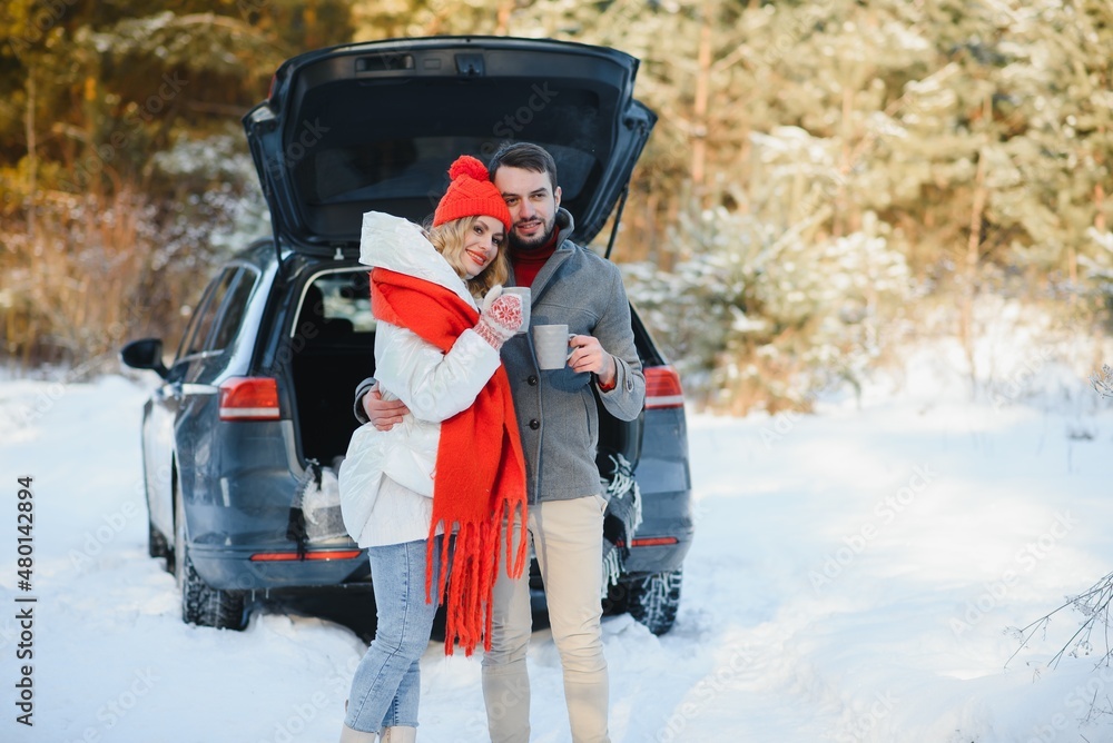 Cute Couple Having Winter Forest Picnic Drinking Tea from Tea Take Away Cup. Nature Picnic. Love Story Date at Car.