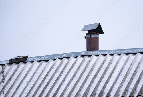 a chimney on an old roof against the sky