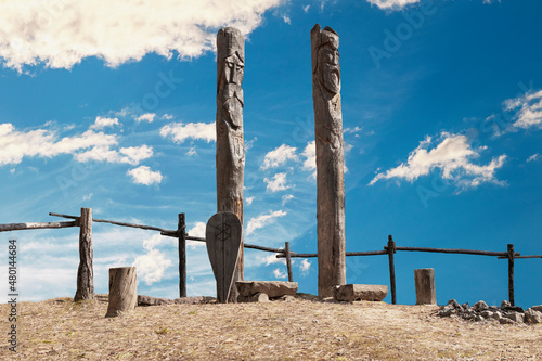 Northern lands. A pagan temple in the taiga with two wooden idols. The image of pagan gods is carved on wooden logs.