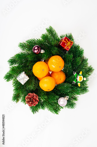 Christmas wreath with tangerines and plate. Studio Photo