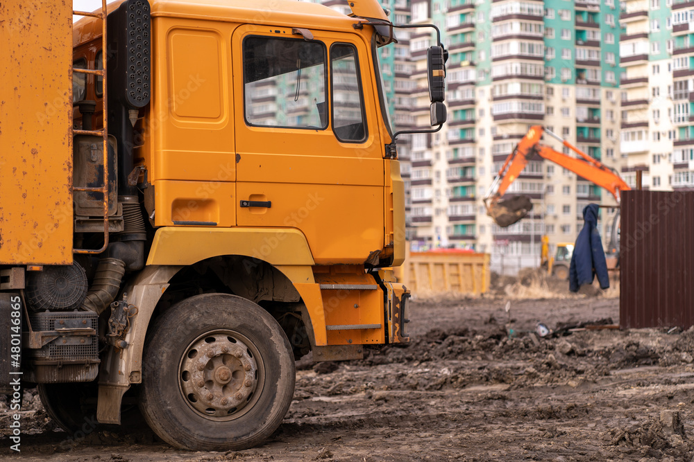 Backhoe digs the ground for the foundation and construction of a new building. Excavator load the sand to the dump truck on construction site