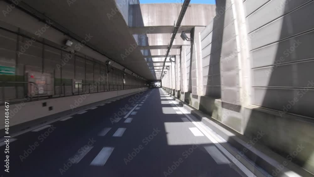 A pov of driving cityscape on the city street through the tunnel in Tokyo in summer A pov of driving cityscape on the city street through the tunnel in Tokyo in summer