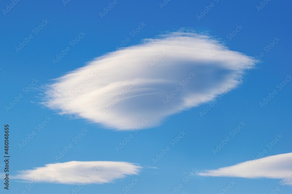 UFO shaped cloud - Lenticularis lentil-shaped coud on the blue sky UFO shaped cloud - Lenticularis lentil-shaped coud on the blue sky