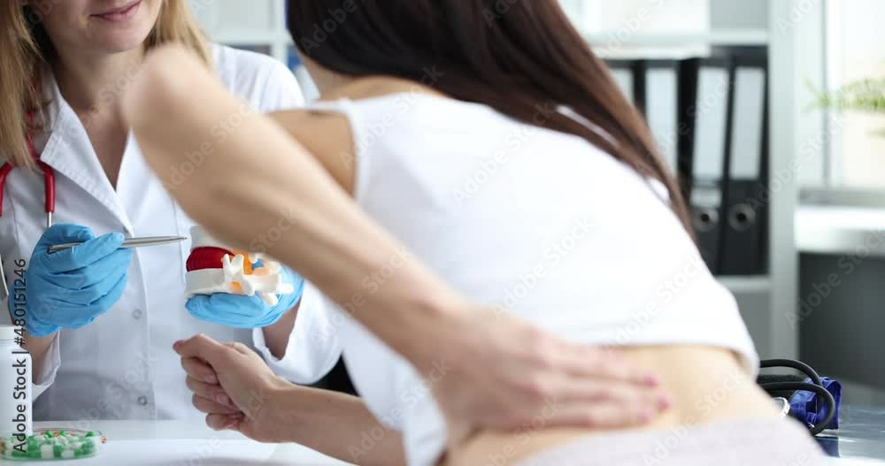 Doctor is talking to a patient with spinal pain Doctor is talking to a patient with spinal pain