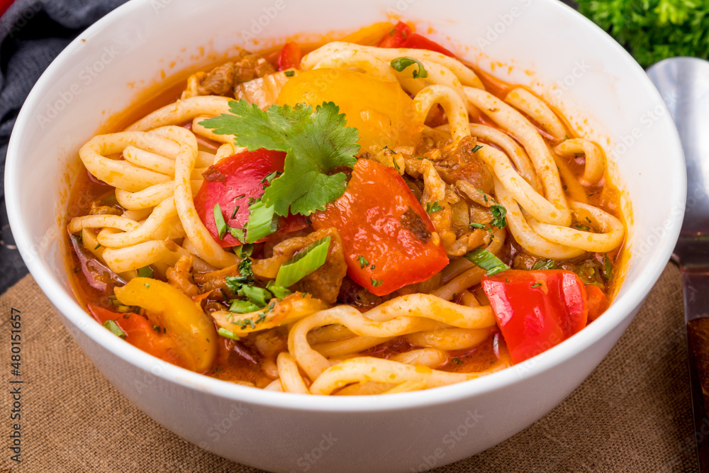 Lagman asian soup with meat, vegetables and noodles, dark table, uzbek cuisine Lagman asian soup with meat, vegetables and noodles, dark table, uzbek cuisine