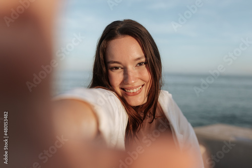 Canvastavla Happy young woman taking a selfie on vacation
