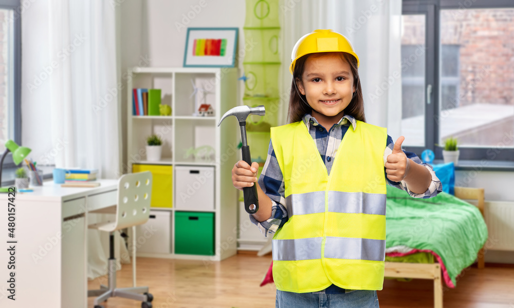 building, construction and profession concept - smiling little girl in protective helmet and safety vest with hammer showing thumbs up over children's room at home background building, construction and profession concept - smiling little girl in protective helmet and safety vest with hammer showing thumbs up over children's room at home background