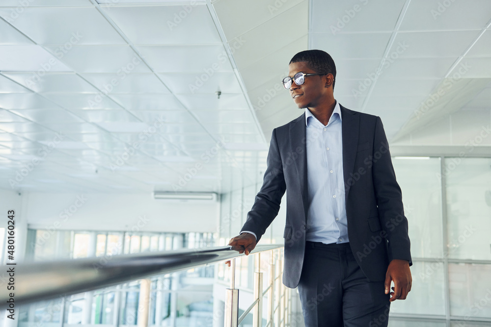 Young african american businessman in black suit is indoors Young african american businessman in black suit is indoors