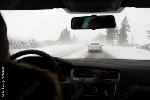 Fototapeta Naklejka Na Ścianę i Meble -  Blowing snow on the road. Difficult weather conditions on the road.