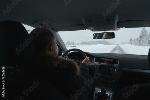 Woman driving a car in winter time.