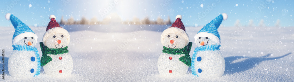 Winter snow snowman background panoramic banner panorama - Little cute Snowmen sits on snow in snowy black forest with snowflakes and sunshine.
