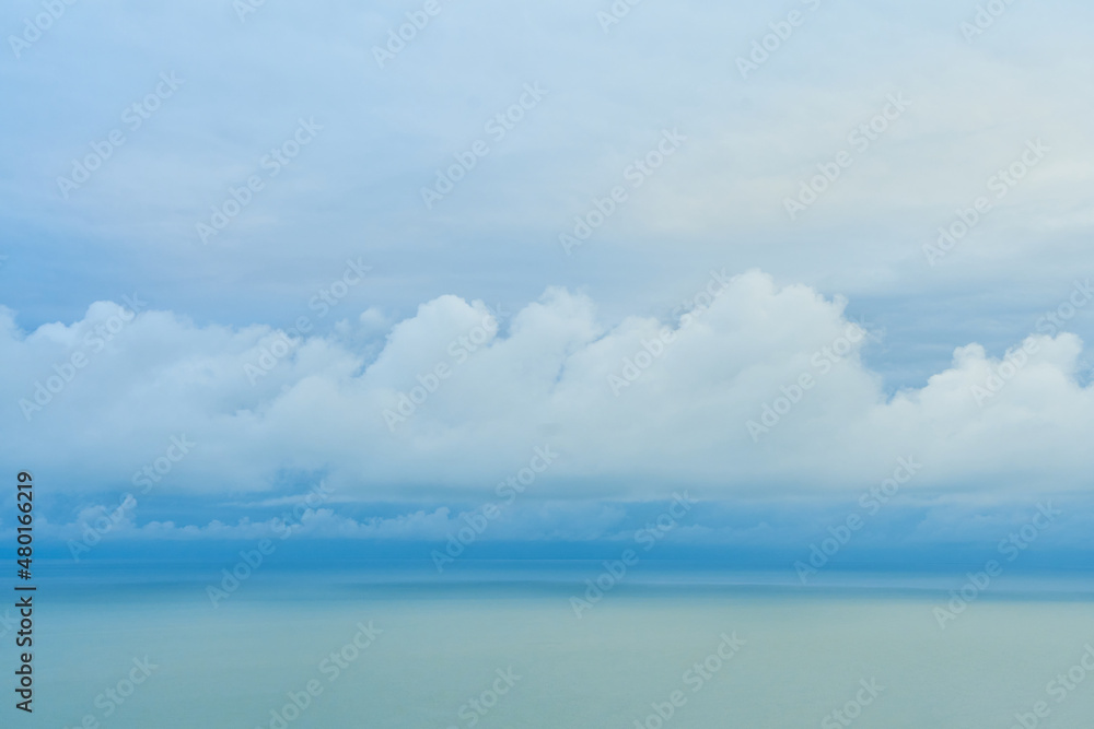 A smooth line of thick clouds on the horizon above the sea