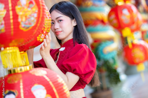 Portrait beautiful smiles Asian young woman wearing red with paper lanterns with the Chinese text Blessings written on it Is a Fortune blessing compliment decoration for Chinese New Year