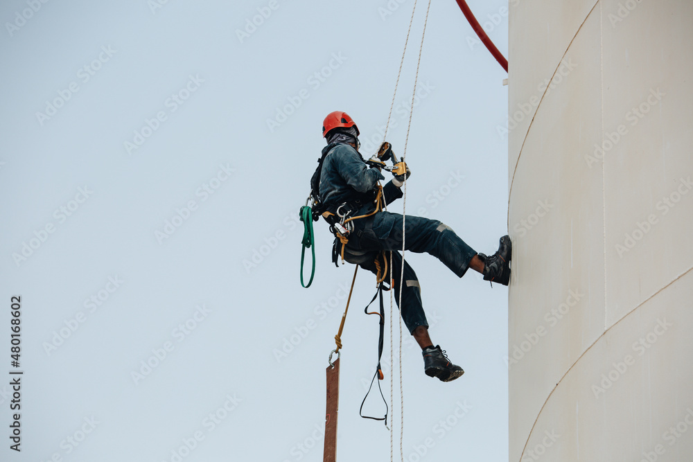 Male worker down height tank shell plate rope ladder  access safety inspection of thickness storage tank gas