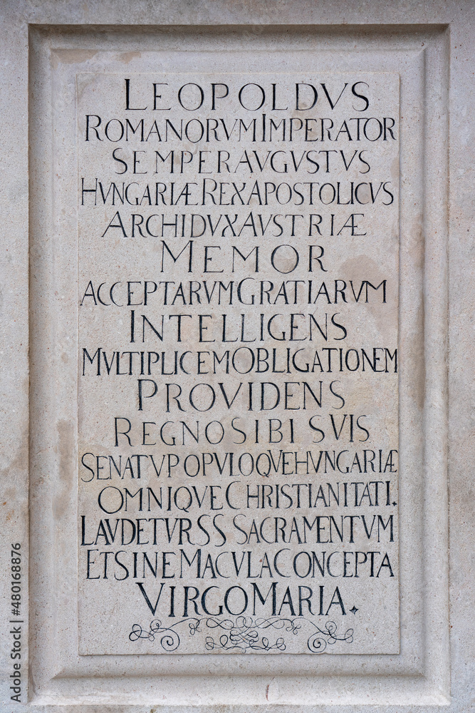 Latin inscription in black uppercase letters engraved in stone, 17th century dedication to German Roman emperor in Bratislava