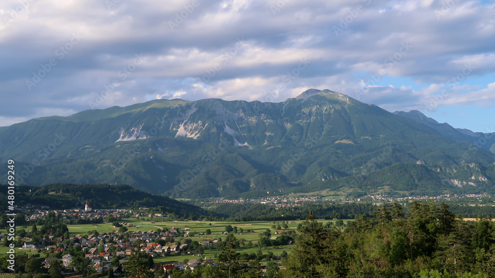 Panoramic view to the town Bled and surrounding mountains through a window
