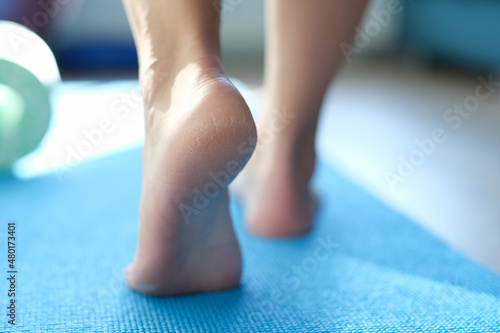 Barefoot dry feet make a step on a blue sports mat © H_Ko