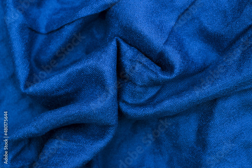 Blue wrinkled knitted as background. Selective focus. Defocus.