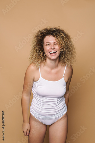 Young blonde woman wearing underwear laughing at camera