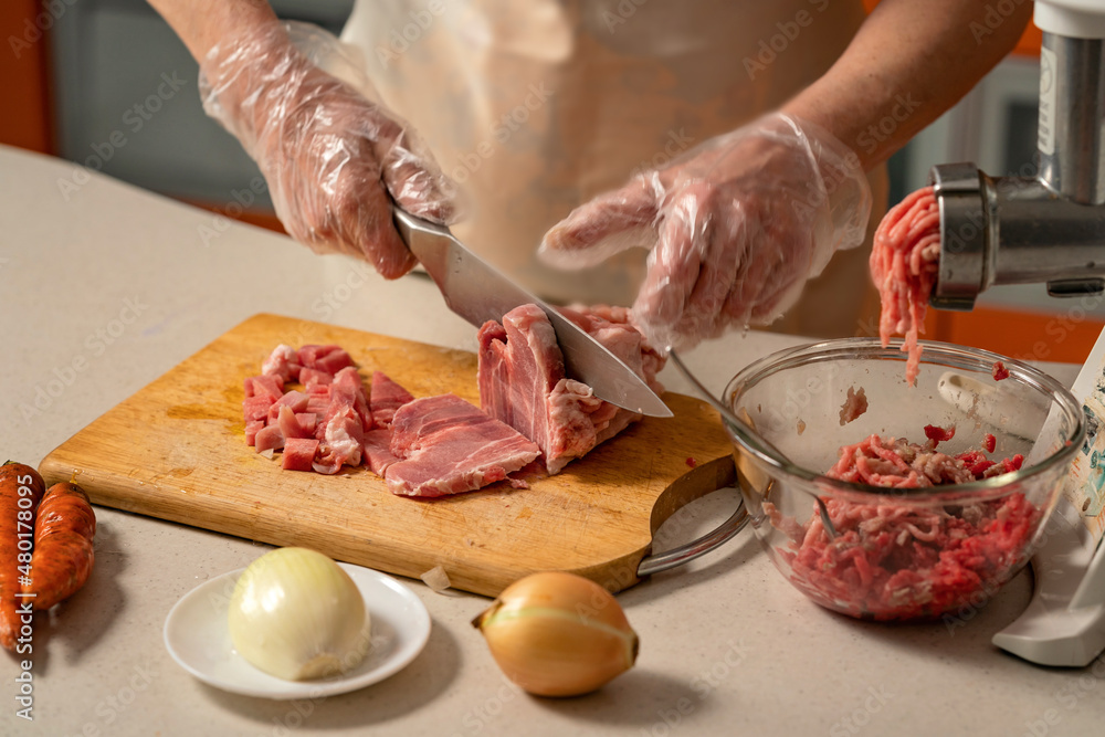 female hands cutting meat for minced meat