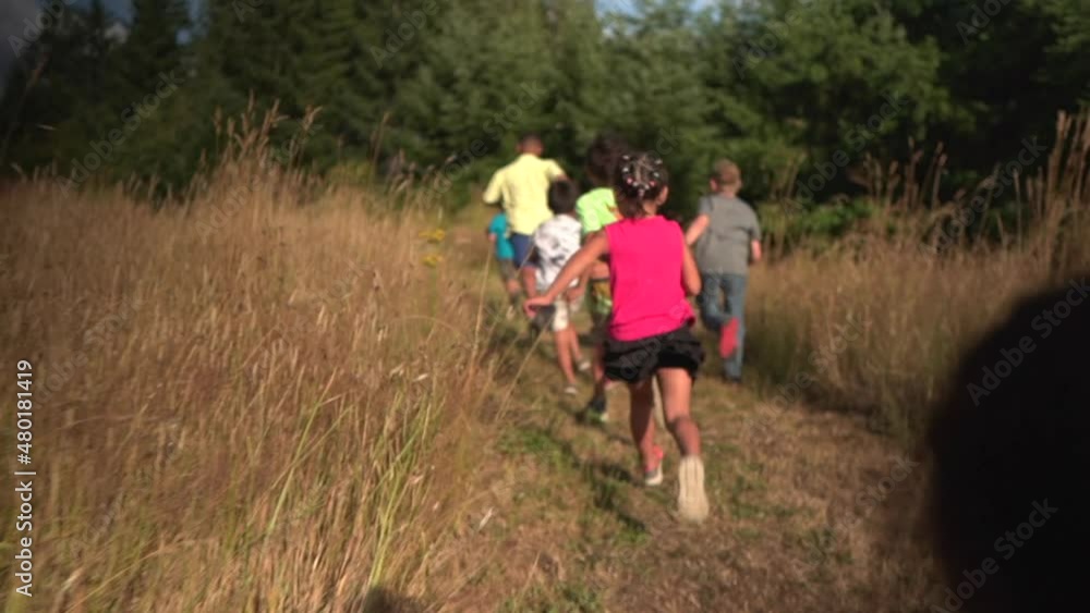 Following Kids Running and Racing in Slow Motion in a golden brown grass field Following Kids Running and Racing in Slow Motion in a golden brown grass field