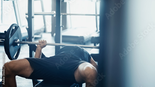 strong sportsman weightlifting barbell in gym.