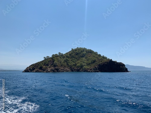 An uninhabited island in the Mediterranean. Islands surrounded by the sea, a quiet harbor for yachts. Seashore against the backdrop of mountains and clear sea. photo