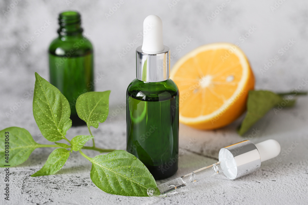 facial serum in a glass bottle with lemon is on the table facial serum in a glass bottle with lemon is on the table