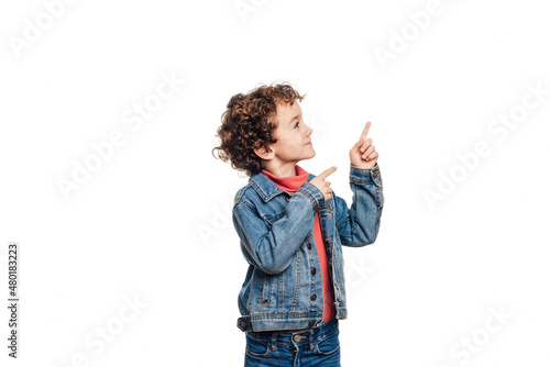 oh look, Portrait of an astonished child pointing to an empty place on white background, expressing his surprise and showing the space for advertising.