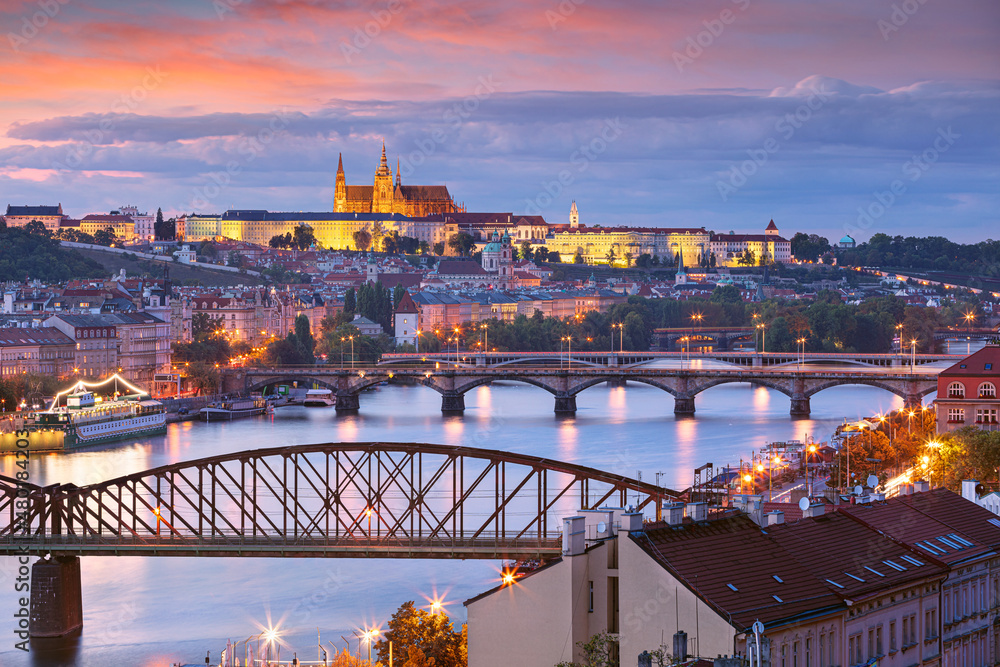 Prague at sunset. Cityscape image of Prague, capital city of Czech Republic with St. Vitus Cathedral and five bridges over Vltava River at autumn sunset.