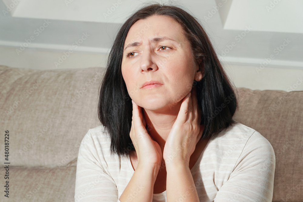 Mature woman touching her neck. Sick woman feels sore throat, painful cough, pharyngitis and hoarseness. Thyroid disorder. Medical and health care. Mature woman touching her neck. Sick woman feels sore throat, painful cough, pharyngitis and hoarseness. Thyroid disorder. Medical and health care.