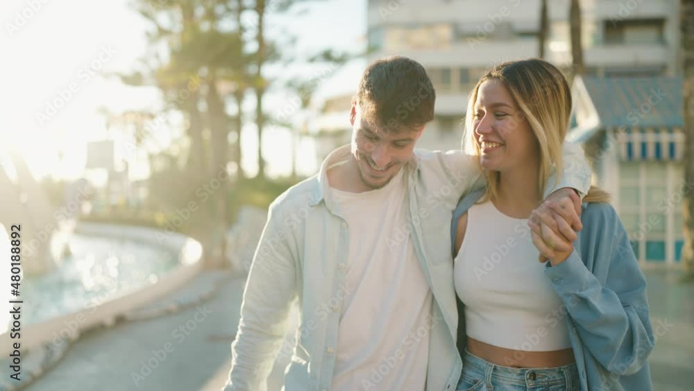 Young couple smiling confident hugging each other walking at street Young couple smiling confident hugging each other walking at street
