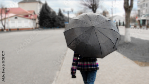 A girl walking around the city under an umbrella