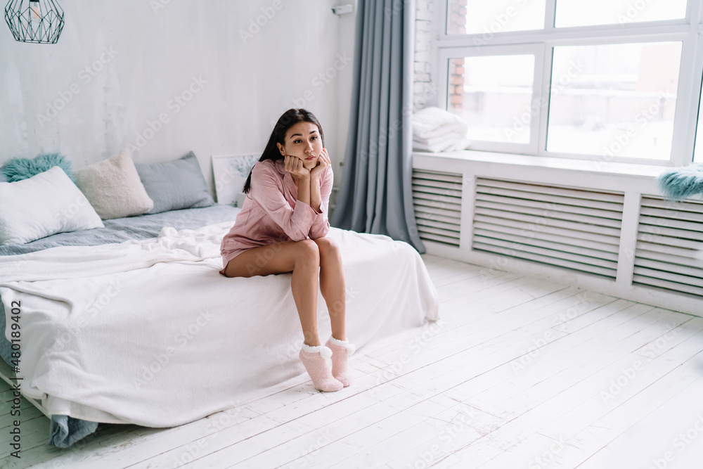 Young sad asian woman sit on on bed and think Young sad asian woman sit on on bed and think