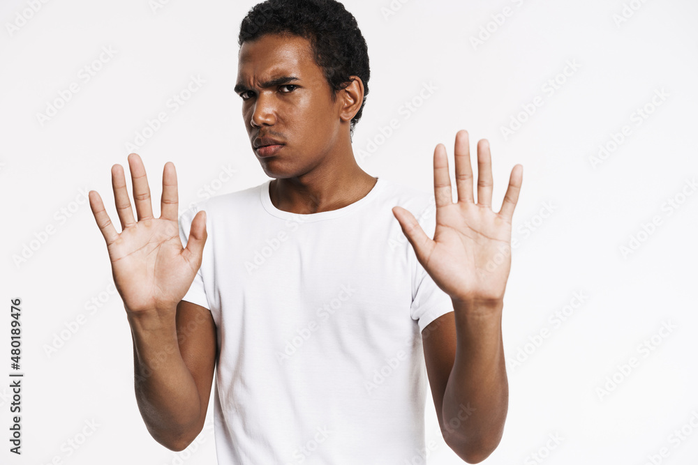 Young black man frowning while making stop gesture Young black man frowning while making stop gesture