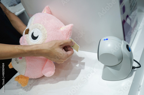 Point of sales example and present; owl pink doll is scaned barcode for sales in toy retail. photo