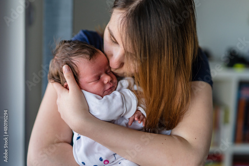 Close up on newborn baby girl in hands of her mother motherhood bonding concept