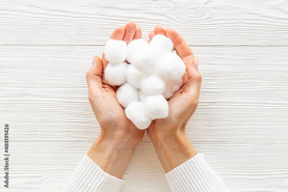 Cotton wool balls in female hands - clean and care for skin Cotton wool balls in female hands - clean and care for skin