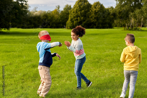 childhood  leisure and people concept - group of happy children playing tag game and running at park