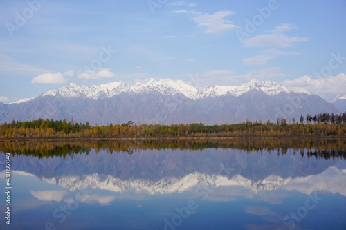 Mountain lake in the taiga and Kodar ridge